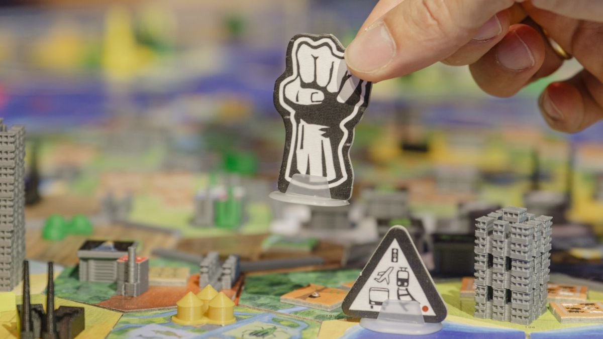 Nahaufnahme einer Faust-Spielfigur auf einem bunten Spielbrett