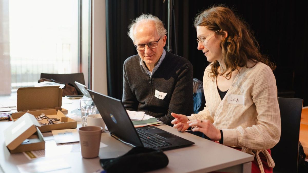 Ein Mann und eine Frau sitzen nebeneinander vor einem Laptop