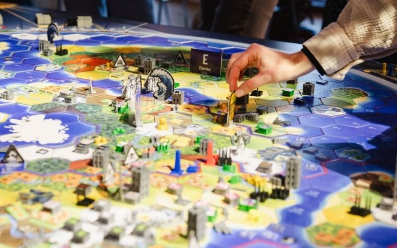 Zwei Personen stehen &uuml;ber das Weltklimaspiel-Spielbrett gebeugt