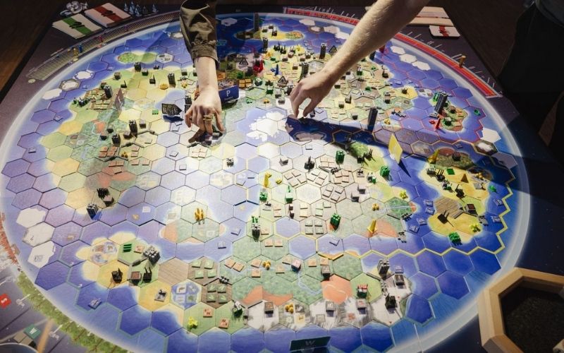 Vogelperspektive auf das Weltklimaspiel-Spielbrett mit Figuren und Karten