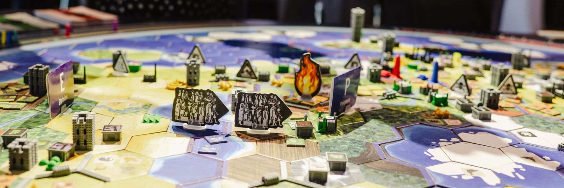 Vogelperspektive auf das Weltklimaspiel-Spielbrett mit Spielfiguren, Karten und Gebäuden